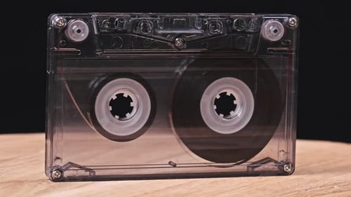 Cassette Tape Rotating on Wood Surface