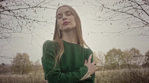Model posing for photo session in nature wearing green dress