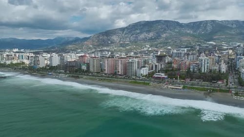 Aerial Video of City Expansion Along Seashore With Modern Towers Coastal Highway and Mountain