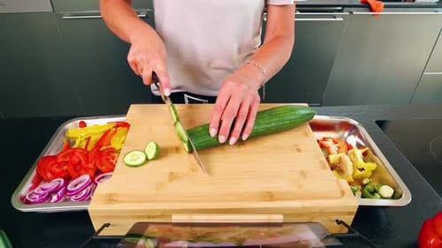 Person Slicing Cucumber Preparing Fresh Salad at Home