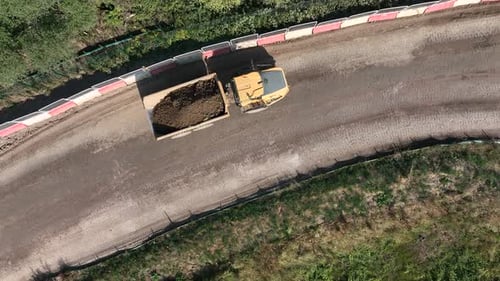Aerial View of Yellow Dump Truck Hauling Dirt
