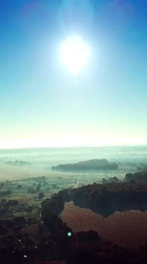 Morning sunrise in the village on misty weather. Panoramic view of beautiful dawn over the roofs