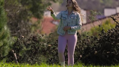 Jeune femme jonglant avec des balles de tennis dans un parc