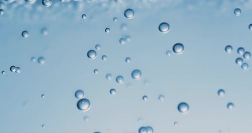 Viele Wasserblasen in blauem Wasser aus nächster Nähe, abstrakte Wasserwelle mit Blasen in Zeitlupe.