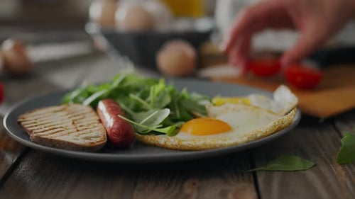 Breakfast plate with egg, sausage, tomato and greens