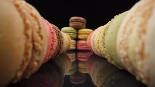 Colorful Macarons Arranged on a Reflective Surface