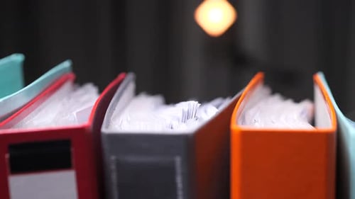 Colorful Binders Full of Paperwork Representing Office Work Archive Storage