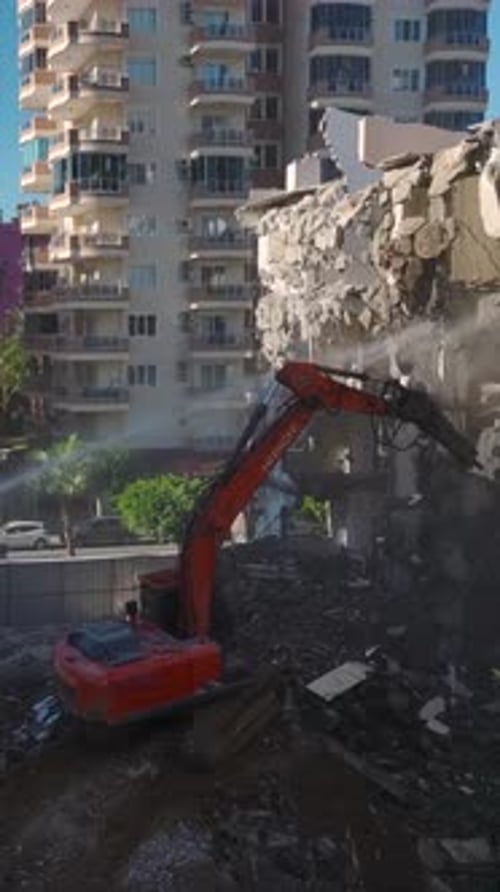 Vertical Video An Excavator Systematically Breaks Apart Walls with a Hydraulic Hammer to Make Way