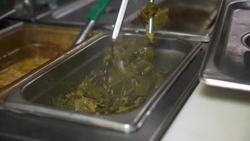 Cuisinier fait sauter le chou vert avec des pinces, au ralenti, 4K
