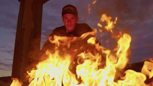 Young Man Poses in Front of Desert Fire