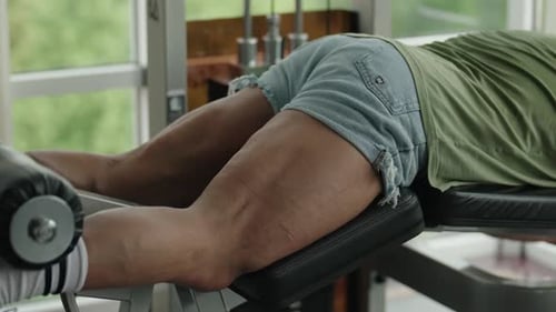 Man Pumping Legs on the Exercise Machine in a Gym