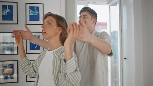 Homme couvrant les yeux d'une femme dans un salon lumineux et lumineux, couple heureux célébrant