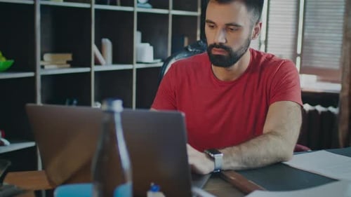 Stylish Businessman Working on Laptop with Serious Face in Office. Responsible Approach