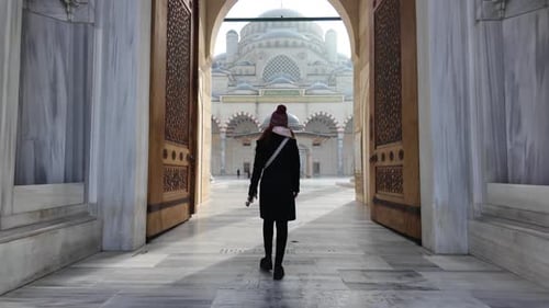 Zeitlupe einer Reisenden, die an einem sonnigen Tag das ikonische Tor der Camlica-Moschee in Istanbul in der Türkei betritt