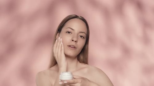 Cream for Skin Care A Young Halfnaked Woman Applies Cream to Her Face Woman with Cream in Her Hands