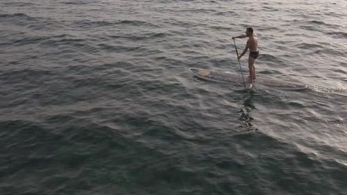Man Stand-Up Paddleboarding in Ocean Aerial View