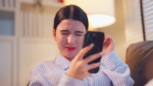 Woman Laughing and Crying While Looking at Phone