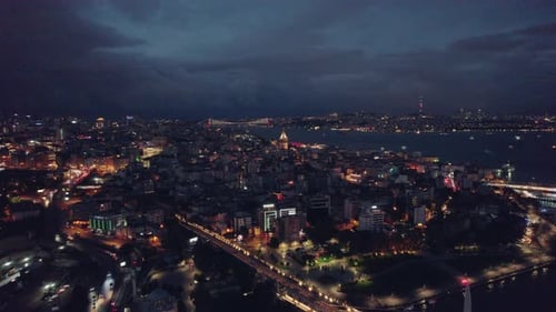 Wide aerial shot of Beyoglu, Istanbul city by night, stunning lights and clouds on the sky, slow mot