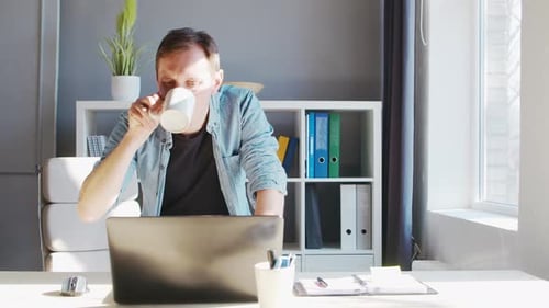 Un jeune entrepreneur de sexe masculin travaille au bureau à domicile sur le lieu de travail informatique d'un travailleur indépendant ou d'un étudiant