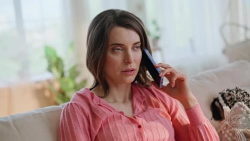 Woman Talking on Phone with a Concerned Expression