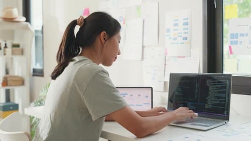 Asia girl IT development programmer typing on keyboard coding programming fixing data code.