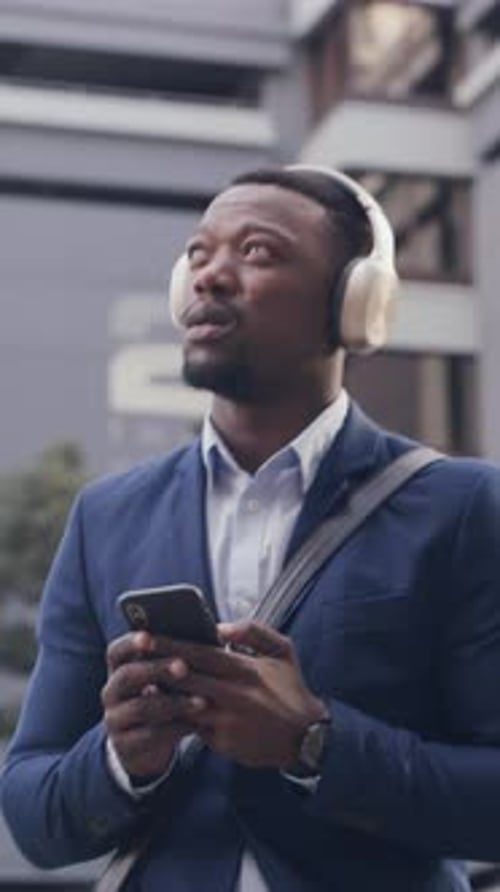 Businessman, walk and phone in city with headphones, streaming music and morning commute for job