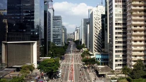 Drone aéreo subindo ampla foto da famosa Avenida Paulista, no centro de São Paulo, com um gigante