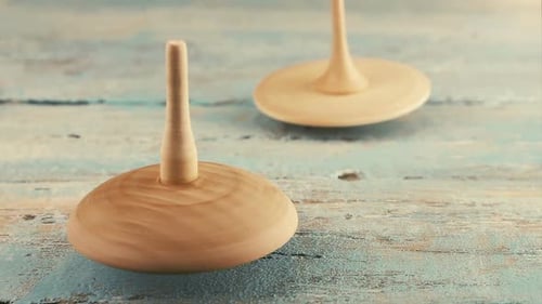 Wooden Spinning Tops Rotating on Rustic Surface