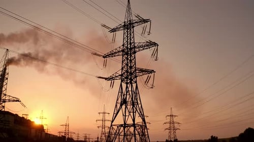 Electricity pylons at sunset. High-voltage electric tower on dirty sky background