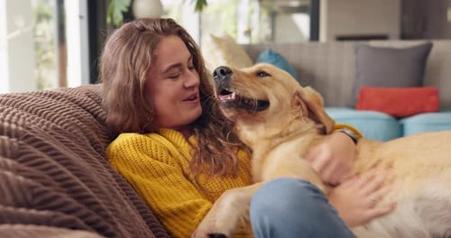 Woman Cuddling Golden Dog on Couch at Home