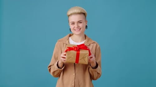 Smiling Woman Presents a Wrapped Birthday Gift