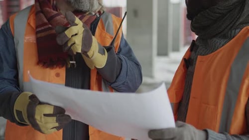 Construction Workers Reviewing Plans at Building Site