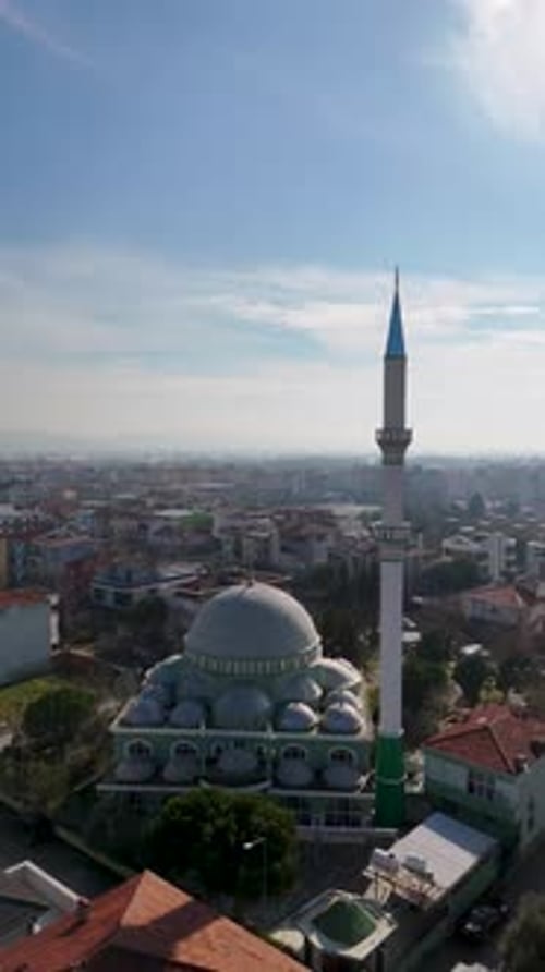 Vue aérienne verticale de la mosquée et des champs agricoles avec la ville en arrière-plan