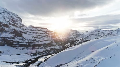 Fast Flight Over Winter Landscape with Snowy Mountains at Sunset, Switzerland, Europe Above