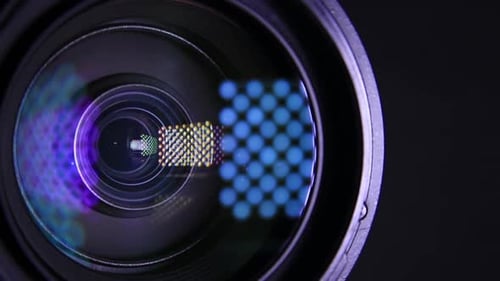 Moving Light Source On Video Camera Lens in the Dark. Close Up.