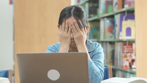 Student Studies Using Laptop at Library Desk
