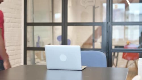 Young Adult Working at Laptop in Modern Office