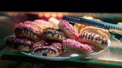 close-up of desserts in the window of delicious fluffy caramel colored donuts with shavings
