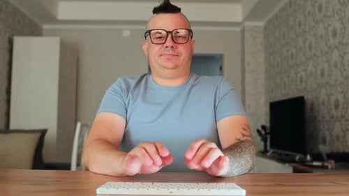 Man Typing on Keyboard at Table