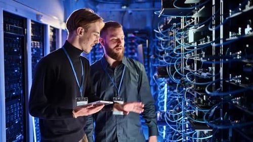 Engineers Inspecting Data Servers in a Blue Lit Room