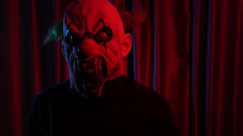 Scary Evil Clown Against Red Curtain