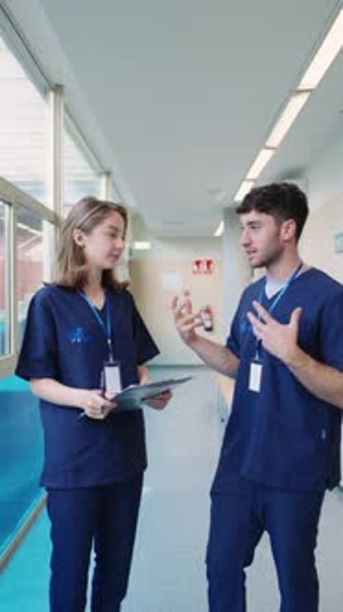 Medical Professionals Discussing Patient Information in Hospital Corridor