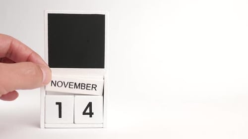 Hand Changing Block Calendar to November Fourteenth