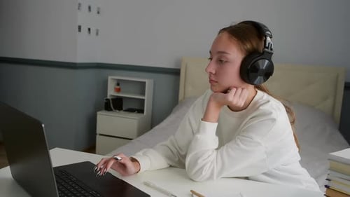Teen Studying Online with Headphones and Laptop