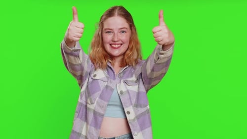 Junge Frau hebt Daumen hoch, stimmt zu oder gibt positive Antwort. Empfiehlt Werbung, gefällt mir, gute Idee