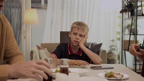 Boy Looks Sad as Parents Argue at Table