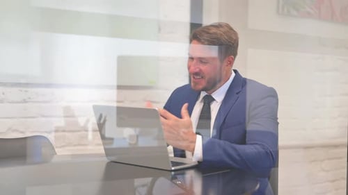 Man in Suit Works at Laptop in Office