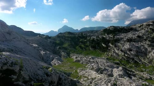 drone view of a valley in the alps mountains on a sunny day