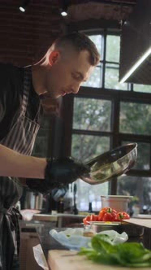 Chef Plating Green Salad Working in Kitchen and Adding Sauce
