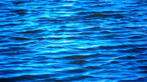 Blaue Wellen auf der Oberfläche eines Sees, Meeres oder Ozeans in Zeitlupe - Hintergrundtextur